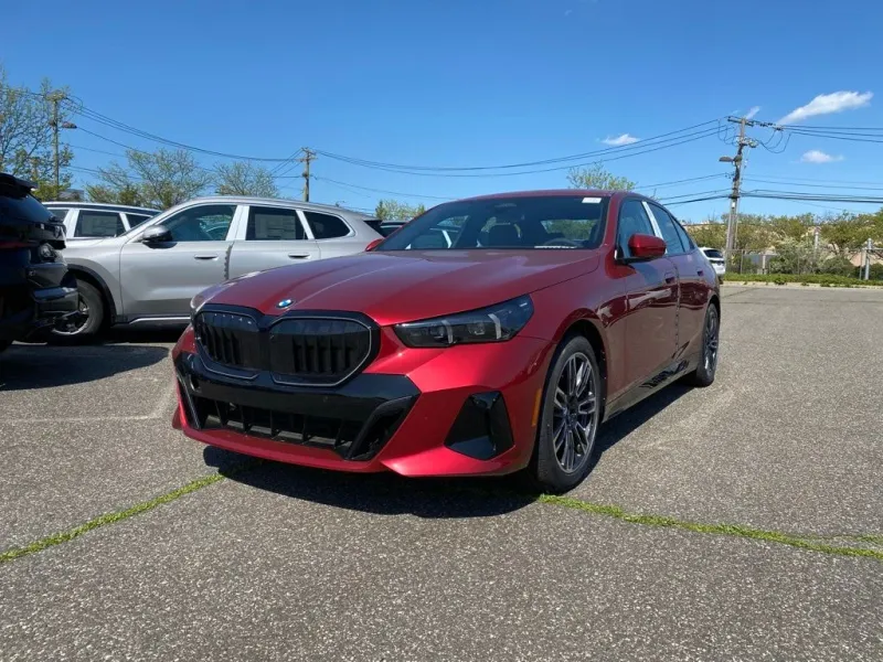 2027 BMW 5 Series 550e xDrive in Vegas Red Metallic — front three-quarter view